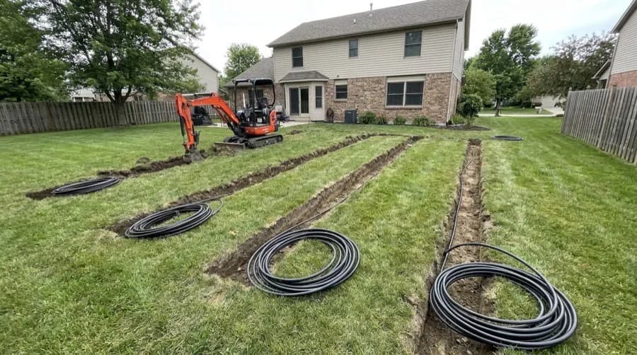 Geothermal ground loops being installed with an excavator in an Ohio backyard